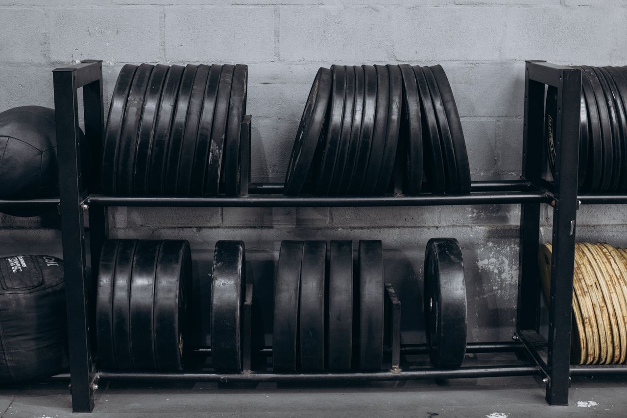 Discos de musculación colocados en un soporte en un gimnasio
